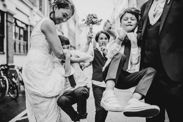 A bride laughing as children play around her