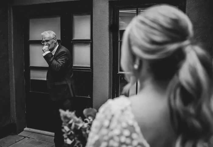 A father watching his daughter through a doorway