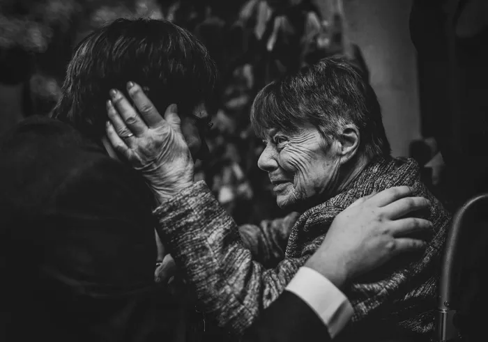 Two guests holding each other in a long embrace