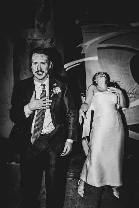 A couple in dramatic light, the groom fixing his tie
