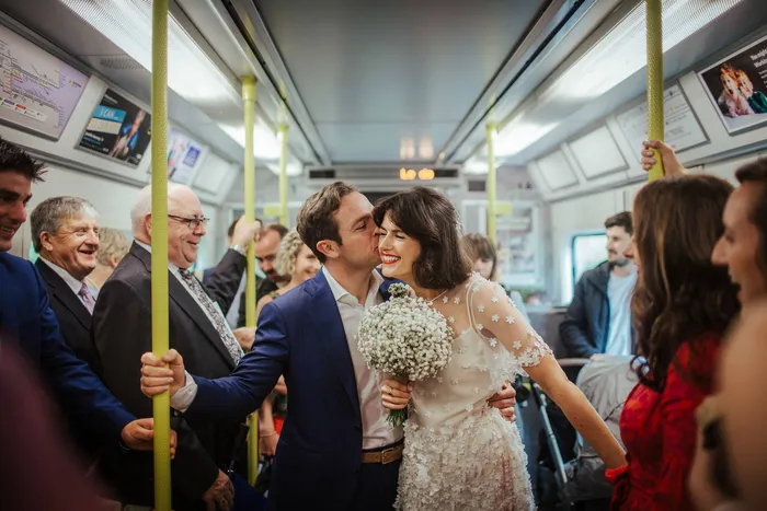 A couple kissing on a packed train carriage
