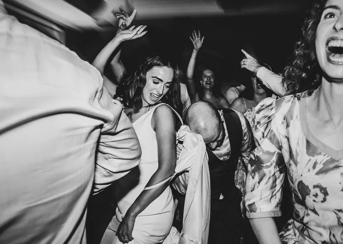 A bride laughing in the middle of a crowded dancefloor