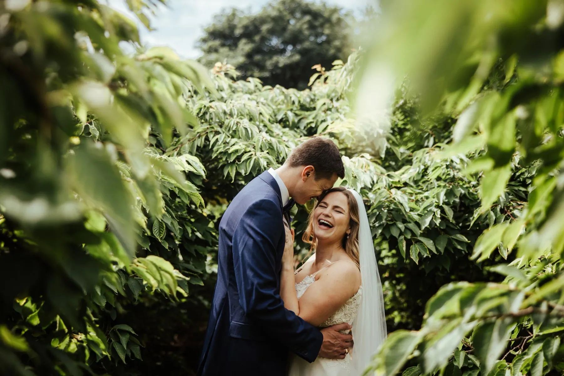 A couple laughing together among the greenery