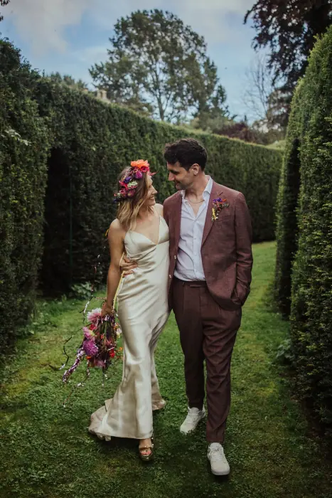 A couple walking a hedged garden path