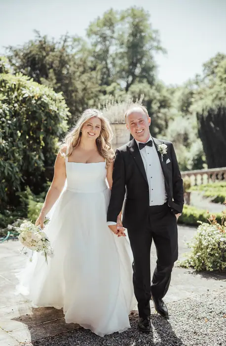 A couple walking a sunlit garden path
